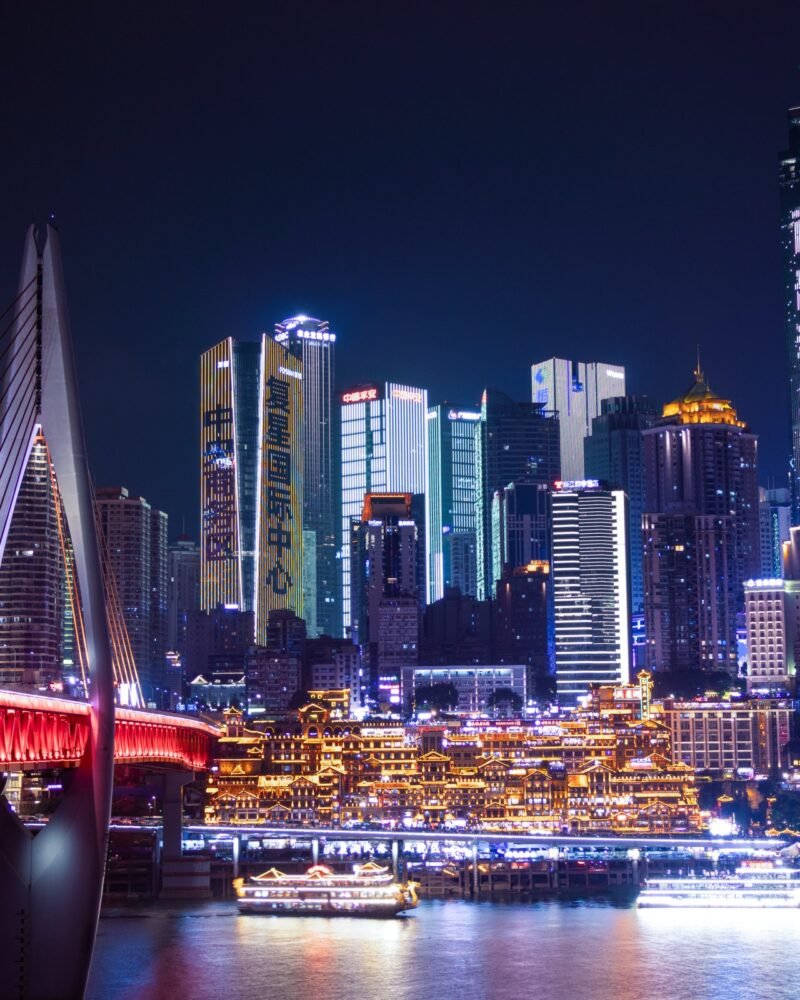 Rascacielos iluminados de Chongqing sobre el río Yangtsé, con el complejo de Hongyadong y el puente en primer plano