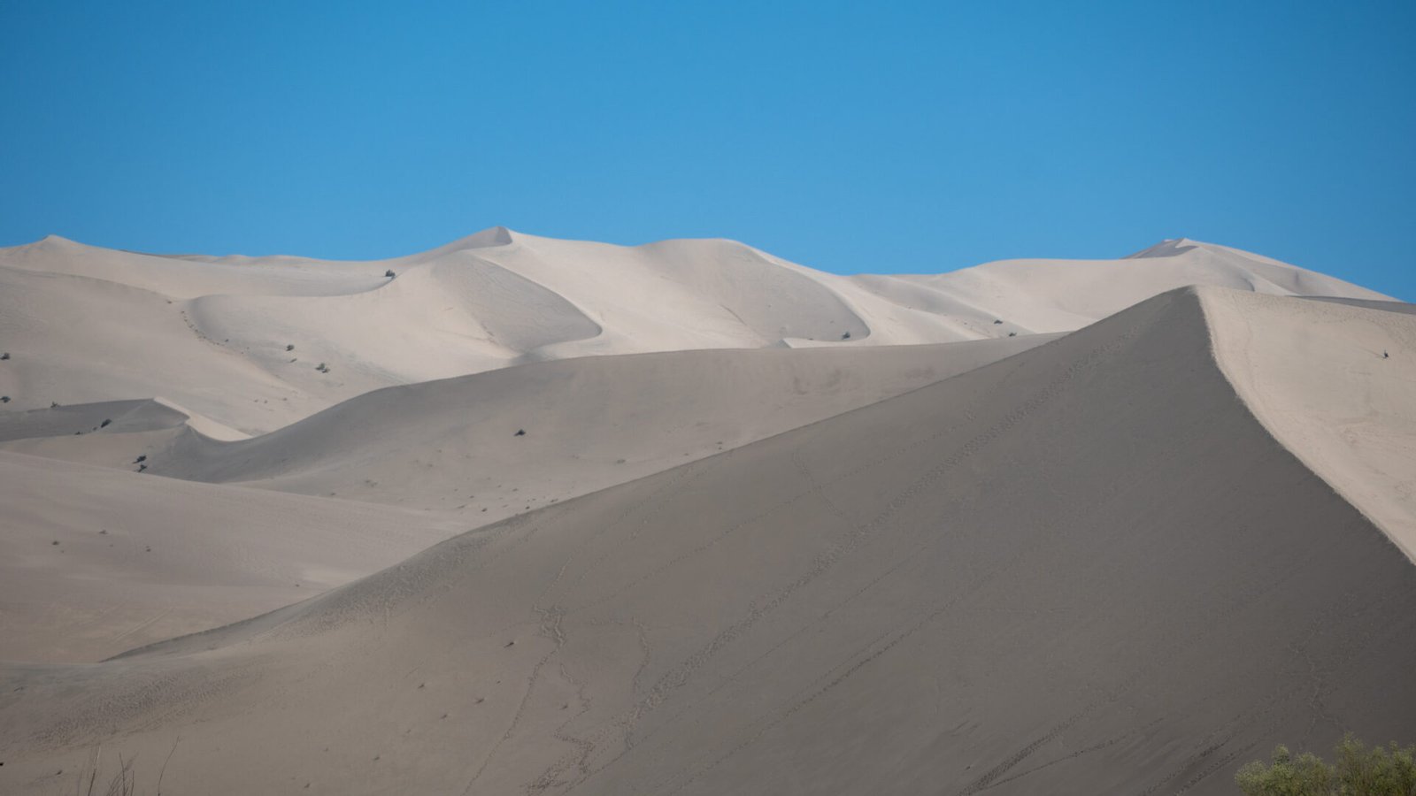 Grandes dunas de arena del desierto de Gobi junto a Dunhuang bajo un cielo azul intenso