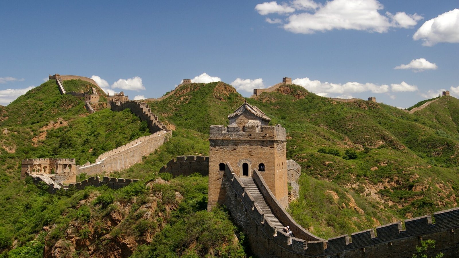 Torres de vigilancia de la Gran Muralla de Jinshanling recorriendo las crestas verdes al norte de Pekín