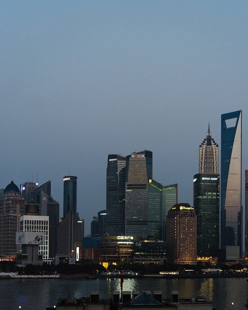Rascacielos de Pudong iluminados al anochecer vistos desde el Bund de Shanghái